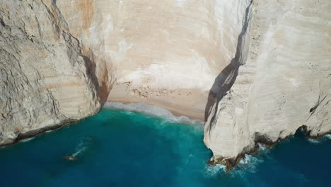 Filmische-Drohnenaufnahmen-Eines-Leeren-Weißen-Sandstrands,-Am-Shipwreck-Beach-Am-Navagio-Beach,-Kristallklares-Wasser