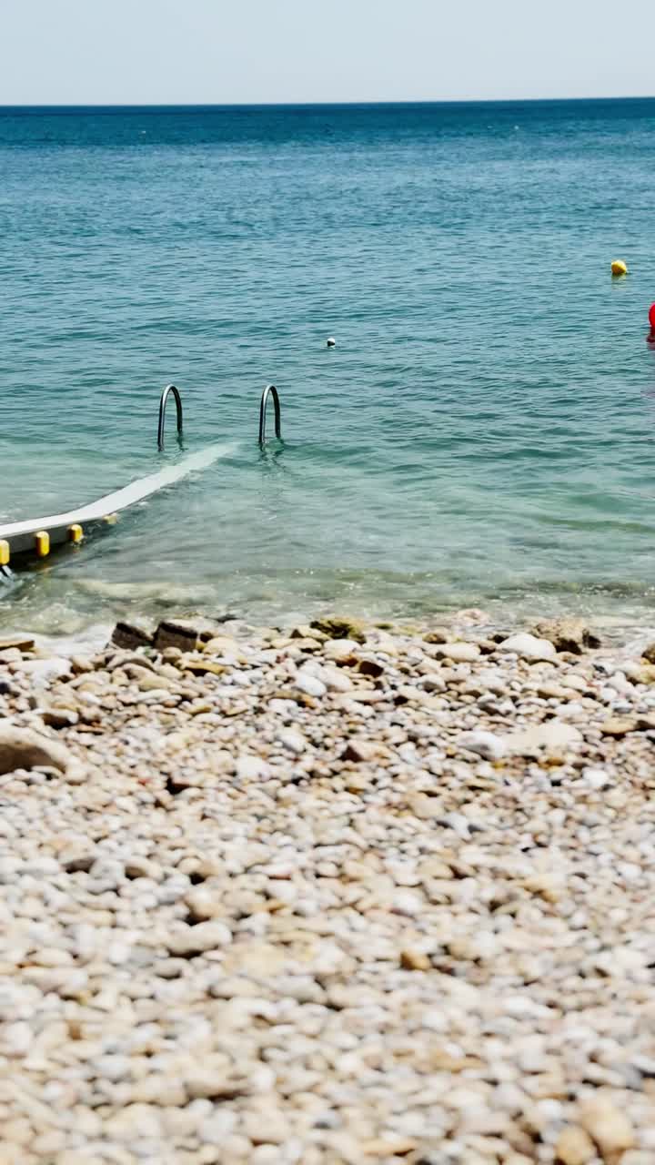 Adkomstrampe til Piraeus-stranden som strekker seg ut i det blå havet