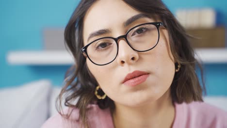 una joven deprimida y reprochable mirando a la cámara.