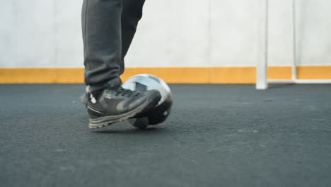 close-up of man controlling soccer ball with precise footwork on sport arena, showcasing agility and athletic skills, vibrant yellow barrier in background