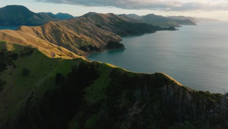 Hermosa-Luz-Del-Sol-Sobre-Las-Escarpadas-Laderas-Del-Paso-Francés-De-Te-Aumiti-Con-Vistas-De-Aguas-Serenas-Y-Tranquilas-Del-Océano-En-Marlborough-Sounds,-Isla-Sur-De-Nueva-Zelanda-Aotearoa