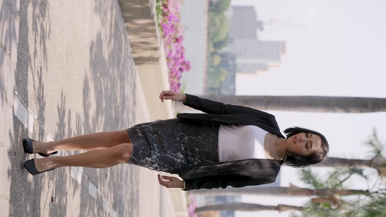 mujer de negocios caminando por el parque de la ciudad.