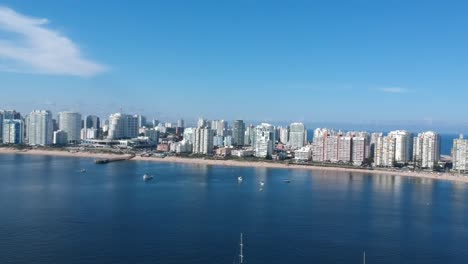 location: punta del este, uruguay.summertimebeatiful day with calm waters.nice beach and modern architecture in the back