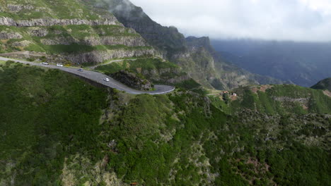 cars driving through dangerous mountain pass to rocha do navio waterfall in madeira, portugal
