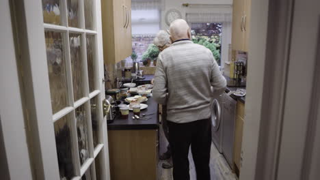 elderly couple preparing food in kitchen