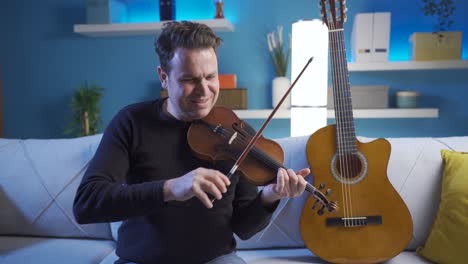 close up of mature male musician composing a song on violin.