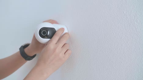 man hands installing cctv camera on wall for security