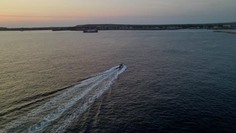 sunset over the mediterranean sea. drone flys over boat with horizon in the background