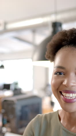 vertical video: smiling african american businesswoman feeling confident, looking at camera in offic