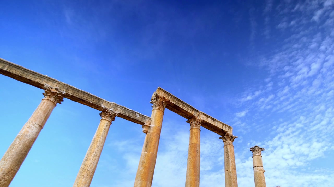 Timelapse diurno di antiche colonne romane sotto un cielo nuvoloso in movimento a Jerash, Giordania. Sito archeologico di Gerasa, architettura storico-greco-romana e turismo del patrimonio mediorientale.