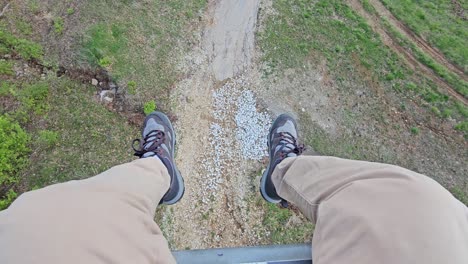 grafton skytour tourist with legs dangling from an open chair cable car in illinois, usa