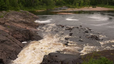 water rushing down a waterfall into a scenic lake