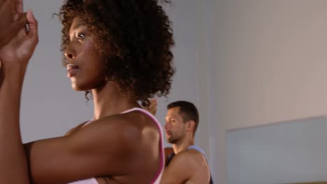 Group-of-people-Practicing-yoga-in-fitness-studio