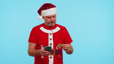 Mann-Im-Weihnachts-T-Shirt-Benutzt-Kreditkarte-Und-Smartphone,-Während-Er-Geld-Beim-Online-Einkauf-überweist