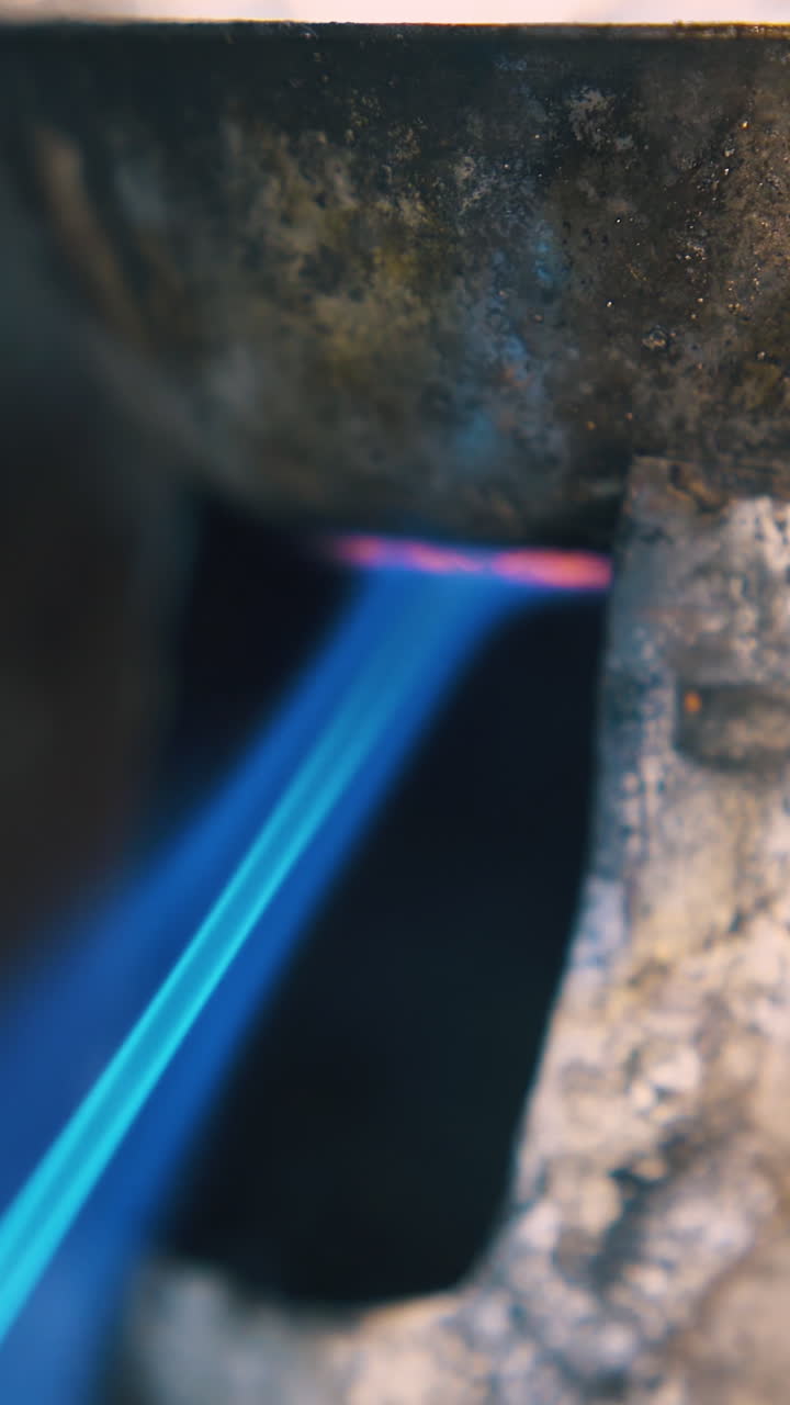 CU shot: heating old little metal bowl with gas burner to process jewelry accessories in light craft workshop close view