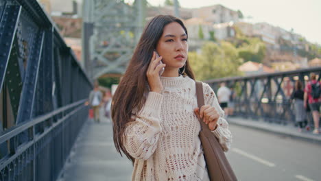 Busy lady speaking cellphone call walking bridge closeup. Lady talking phone
