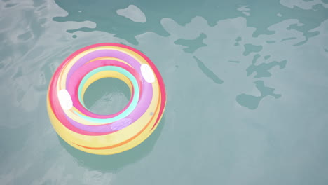 a colorful inflatable ring floats on a pool''s surface