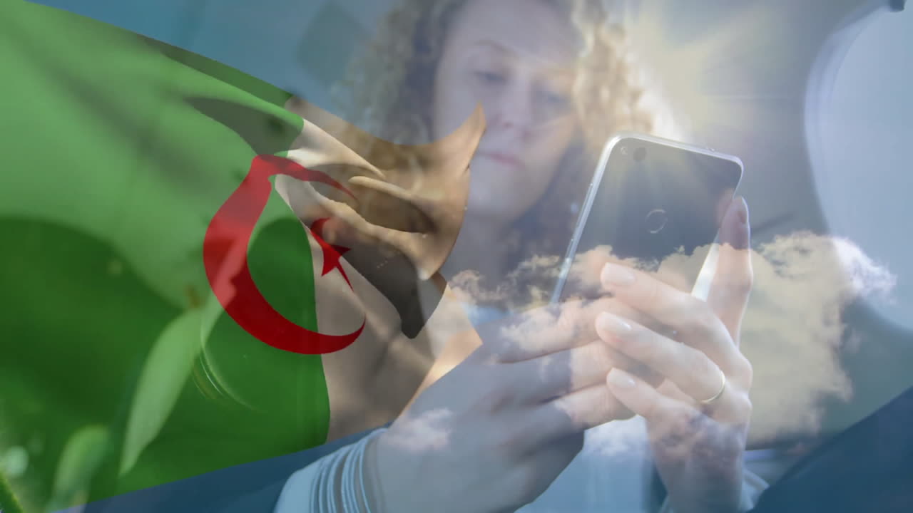 Waving Algerian flag, person using smartphone with cloudy sky backdrop