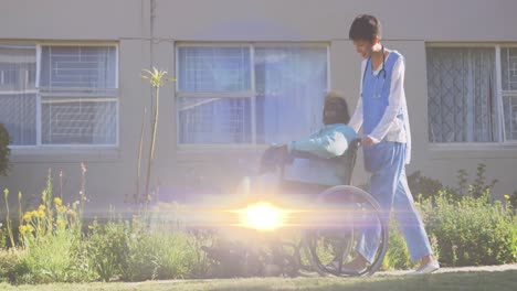 Animation-of-light-moving-over-female-nurse-pushing-senior-in-wheelchair