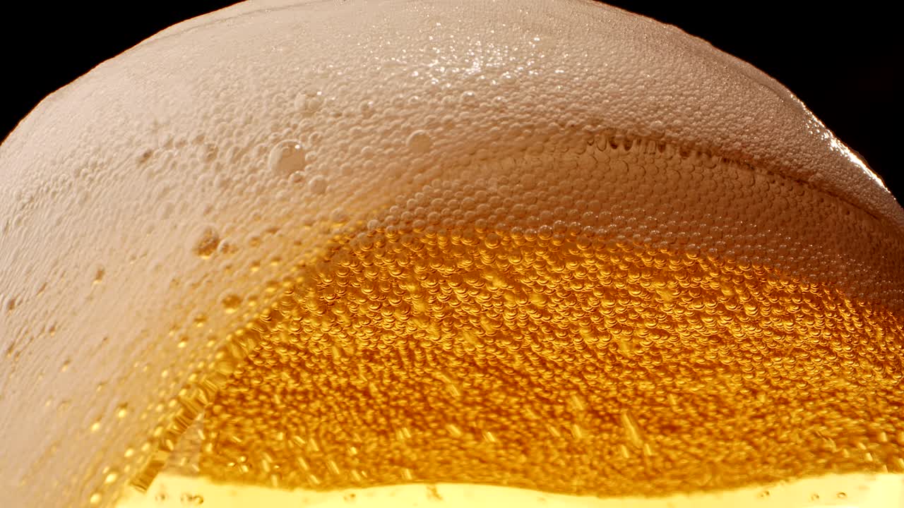 Beer with foam spilling over glass