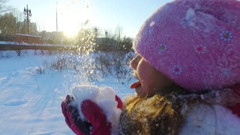 little girl blowing snow from hands. winter wonderland