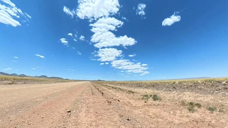 tilting up desert open road time lapse of clouds forming as a car passes
