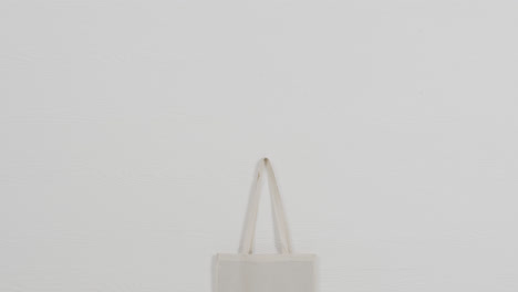 close up of white bag on white background, copy space, slow motion