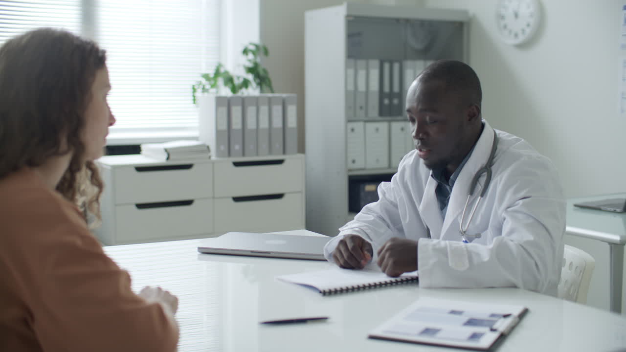 Female Patient Signing Medical Agreement and Shaking Hands with Doctor