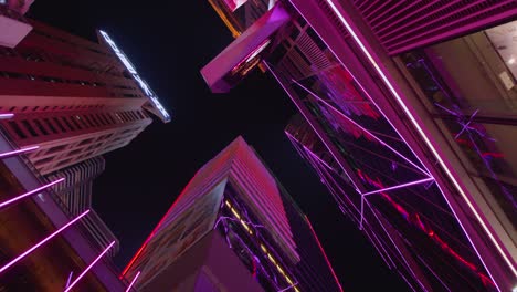 Looking-up-shot-of-skyscraper-at-night-lighting-up-the-night-giving-a-cyberpunk-vibe-to-the-scene