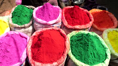 zoom in on vividly colored bags of holi powder at the spice market in old delhi