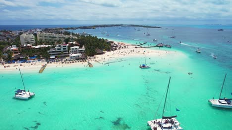 4K-Drone-View-Of-Luxury-Boats-In-Blue-Water-Off-Mexico-Playa-Norte-Beach-Coast-Busy-With-Tourists