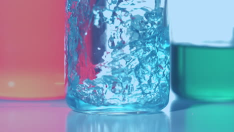 animation of red dots floating over blue reagent pouring into glass