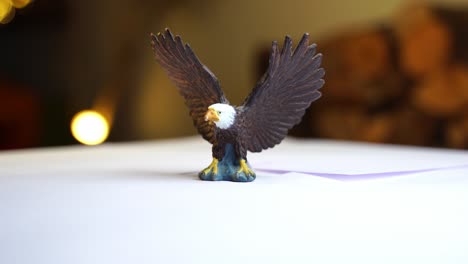 small toy bald eagle rotates against dark background