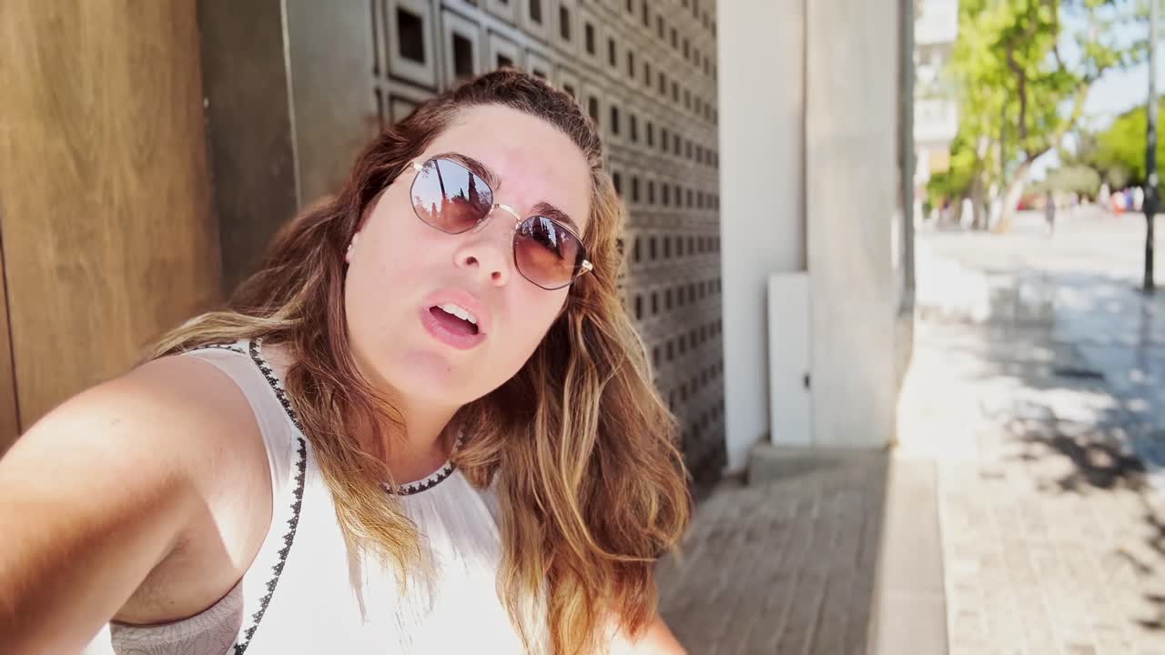 Vlogger nói chuyện trực tiếp với máy quay trên một con phố đầy nắng