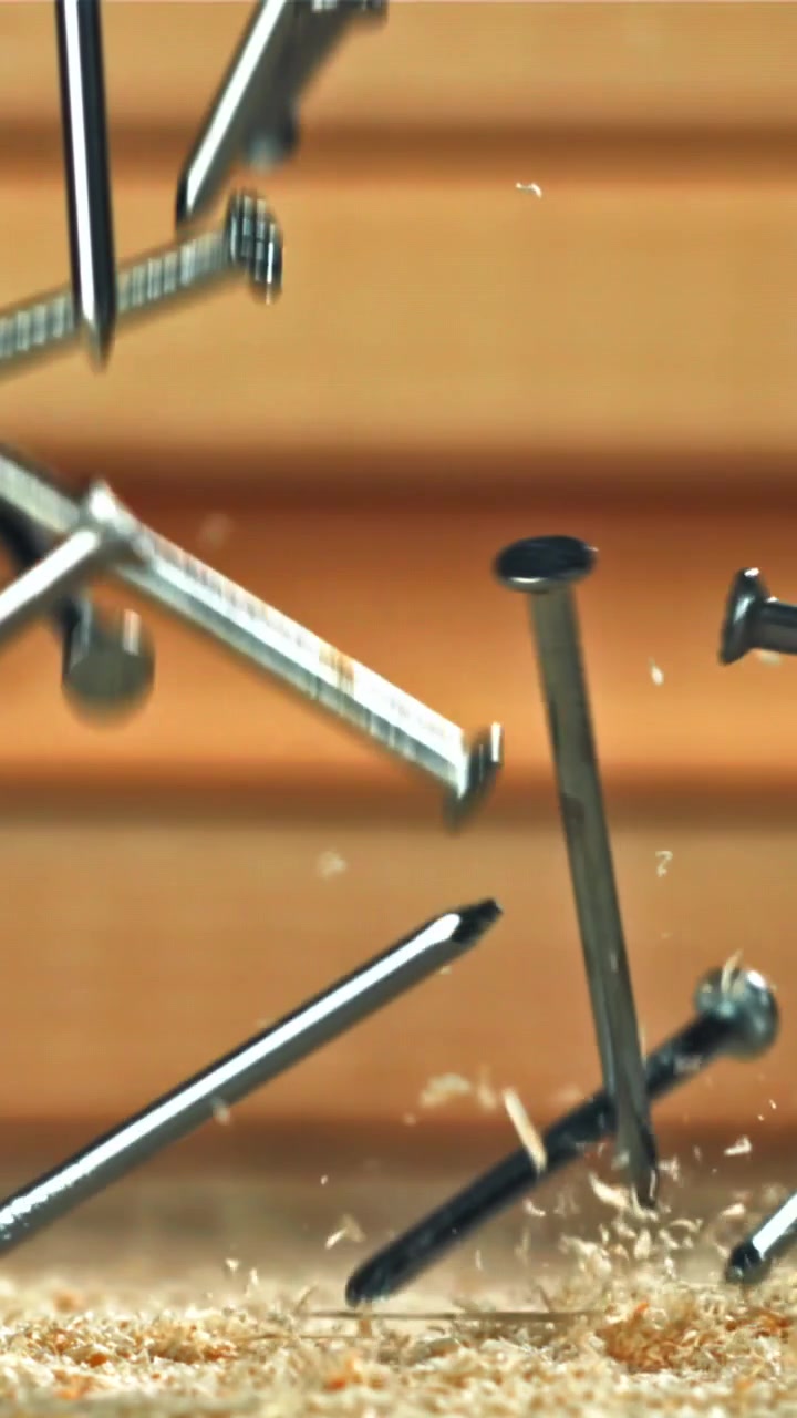 Slow Motion Nails Falling onto Sawdust