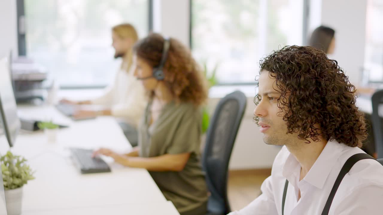 Man working with computer in a coworking next to colleagues