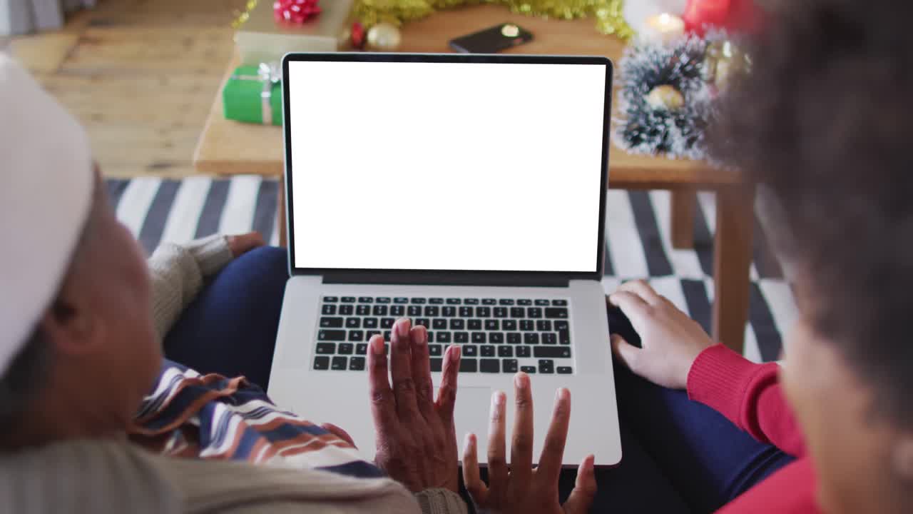 African american mother with daughter making laptop christmas video call, copy space on screen