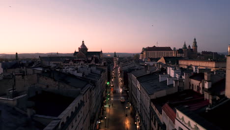 Vista-Aérea-Del-Casco-Antiguo---Casas-De-Vecindad-En-La-Calle-Grodzka-Y-El-Castillo-De-Wawel-En-Cracovia,-Polonia-Durante-El-Amanecer-Mágico-Con-Luz-Matutina-Suave-En-Colores-Rosa-Y-Pastel