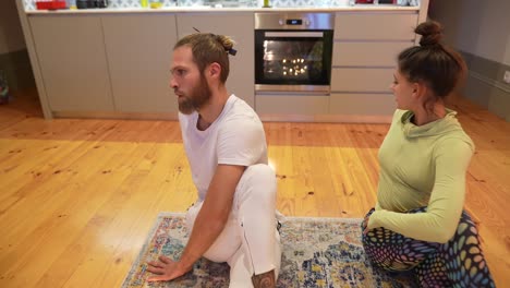 couple doing yoga poses in their kitchen