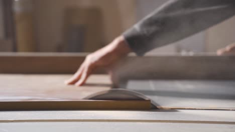 carpenter cutting wood with electric machine, close-up.