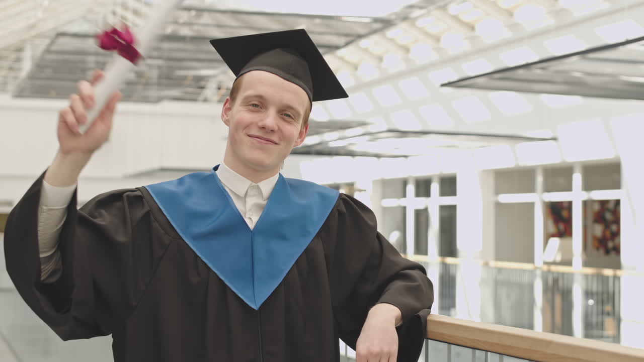 Portrait of Cheerful Male Graduate in University