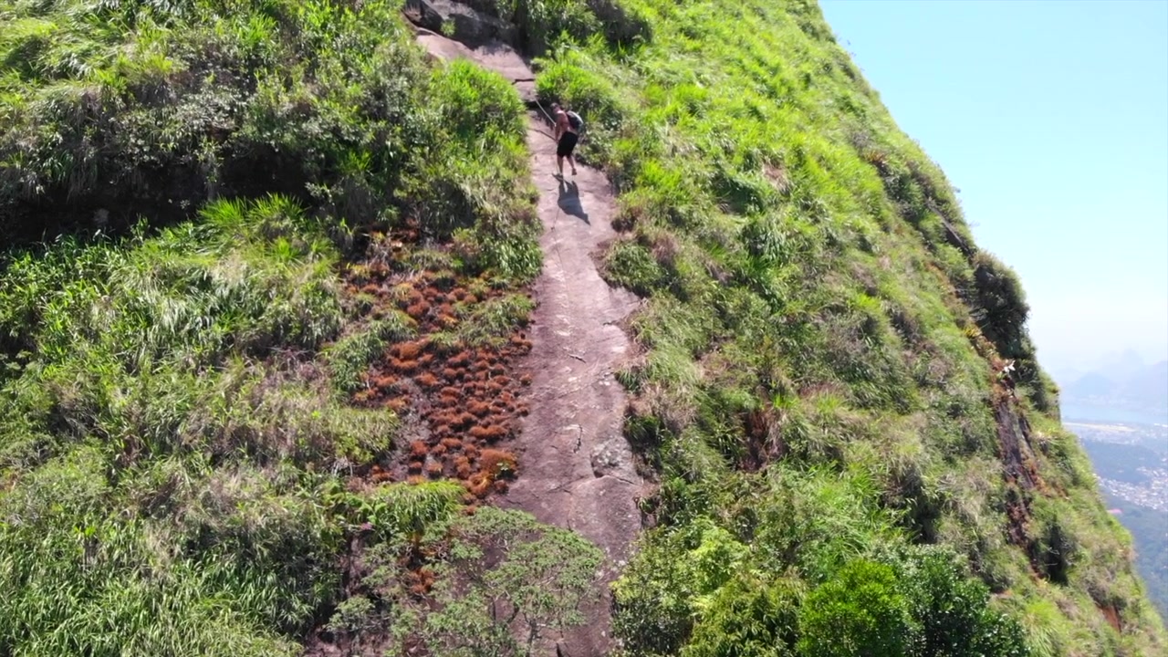Homem subindo uma parte da famosa Pedra da Gávea, no Rio de Janeiro