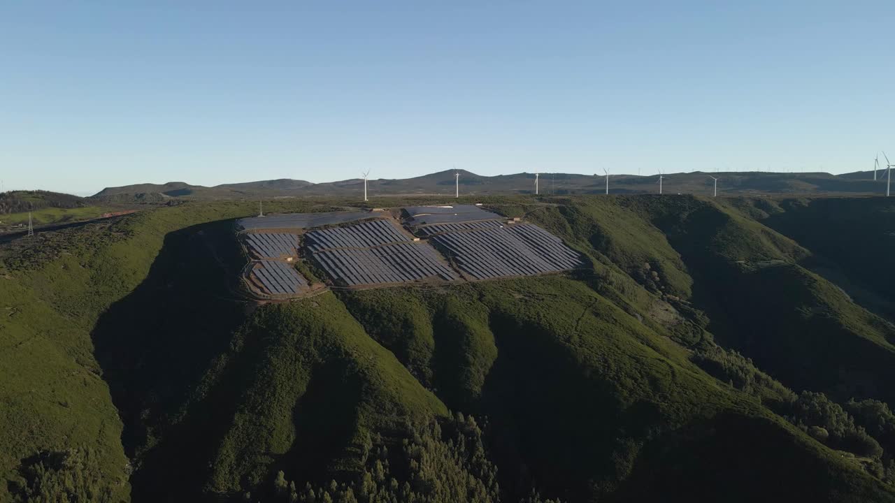 Aerial view of a photovoltaic farm and a wind farm on top of a mountain in Paul da Serra Madeira island