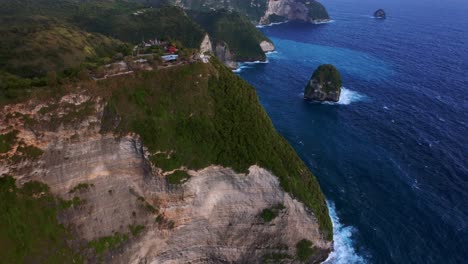 mountains and ocean at kelingking beach in nusa penida island, bali, indonesia - aerial shot