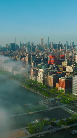 white thick smoke coming closer to the manhattan island. amazing new york cityscape lit with sunshine. vertical video