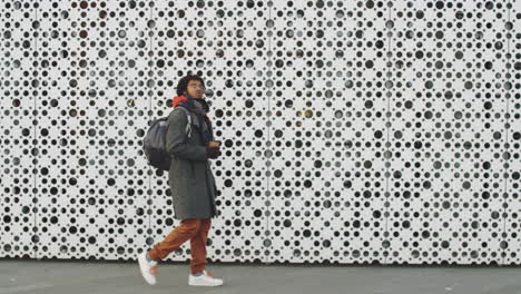 young man walking in the city with a backpack