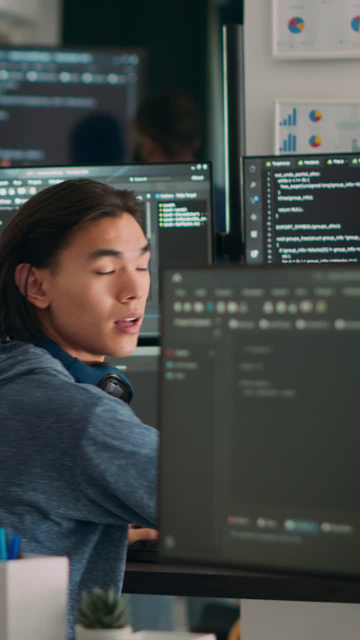 Vertical video: Asian system engineer asking coder for help with html code