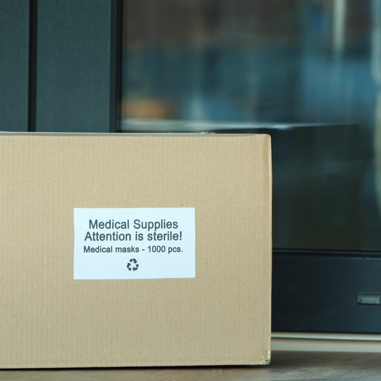 택배는 보호용 의료용 마스크가 있는 상자를 문앞으로 가져옵니다.