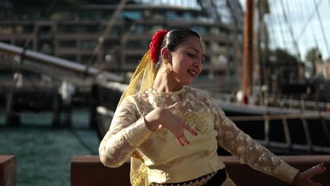 woman performing the classical dance of india in front of sydney harbour bridge in australia - medium shot