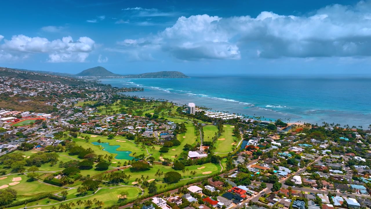 Niedrige Skyline am Ufer von Honolulu, Hawaii. Beeindruckender Blick auf die Stadt mit azurblauer Wasserlandschaft des Pazifischen Ozeans und weißen Wolken im Hintergrund